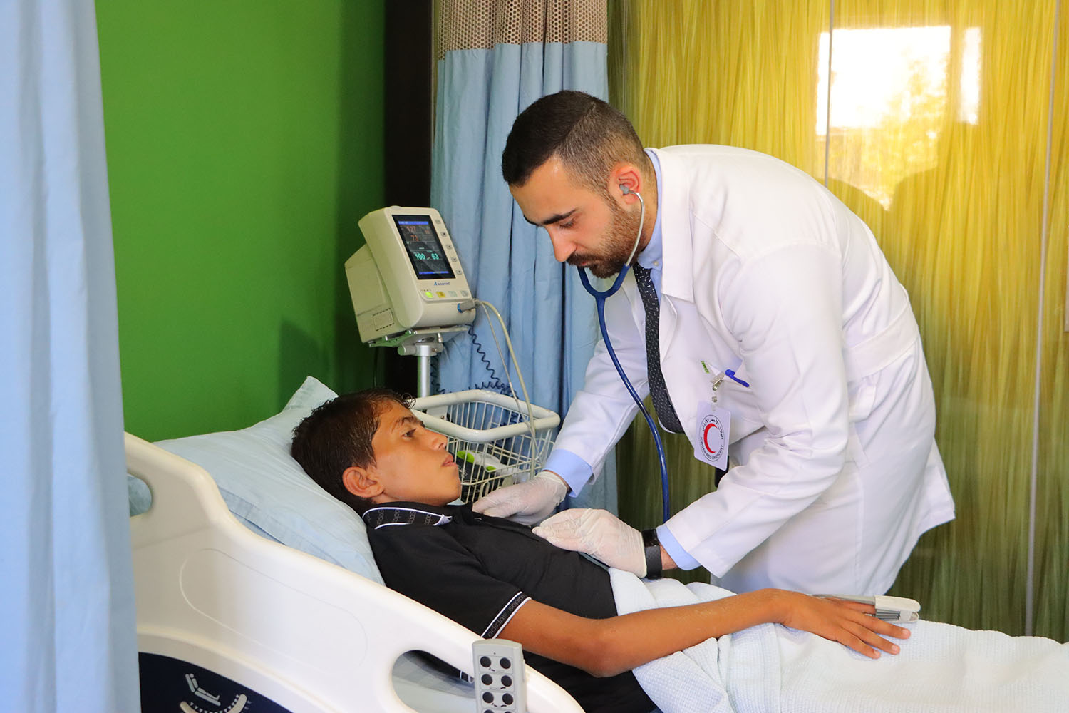 At the Jordan Red Crescent Hospital in Amman, a doctor gently examines a child who was recently evacuated from Gaza.