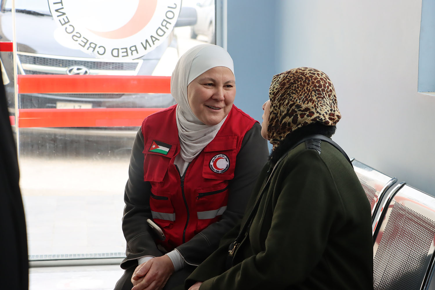 At the Jordan Red Crescent Hospital in Amman, Jordan Red Crescent staff member Nidaa sits with a woman who was recently evacuated from Gaza, providing her with care and compassion after all she has endured.