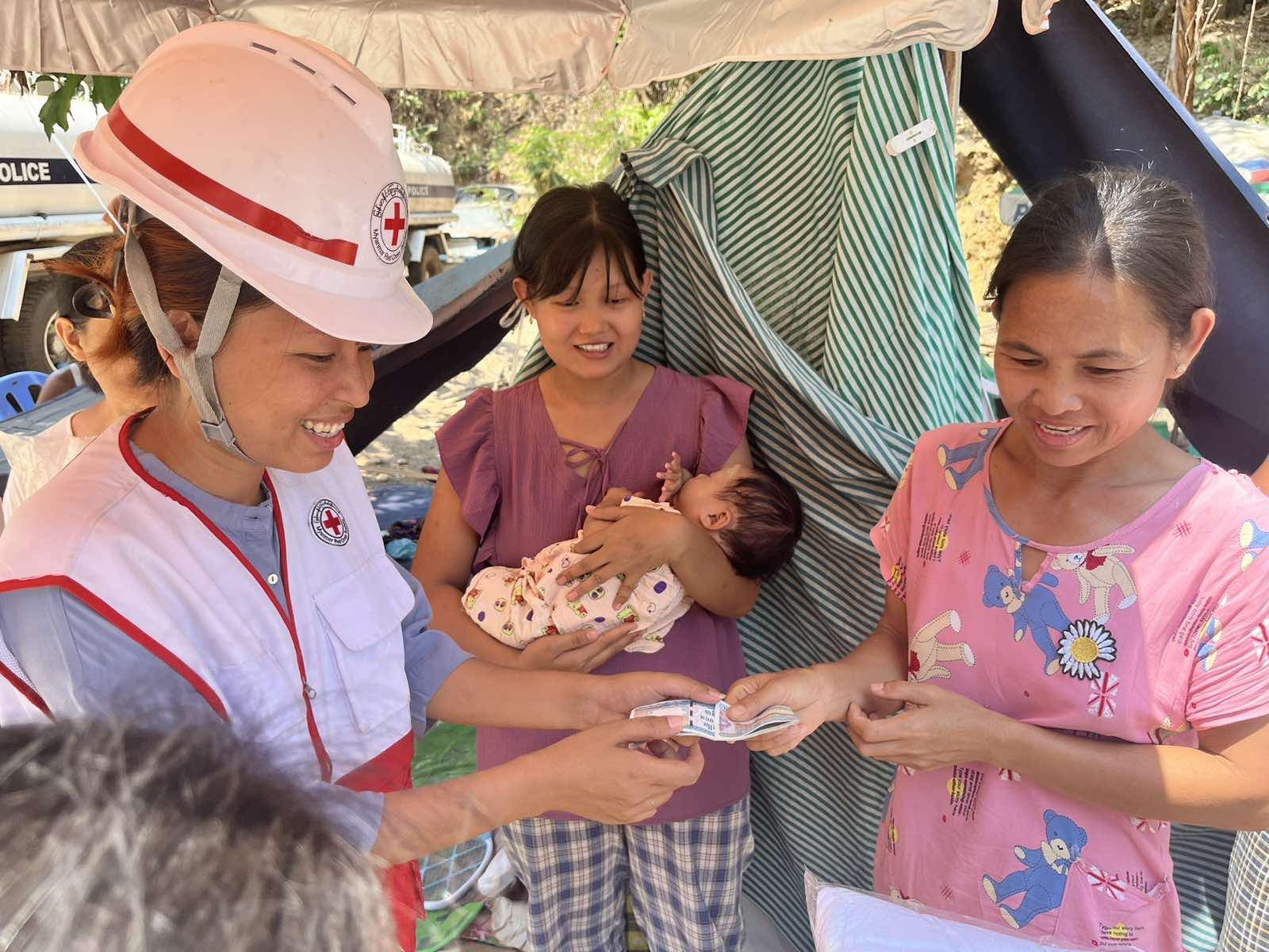 As recovery efforts continue, volunteer May Tha Gyan provides more than first aid. Here, she checks in with a family living in a makeshift shelter and provides cash assistance so they can meet their basic needs.
