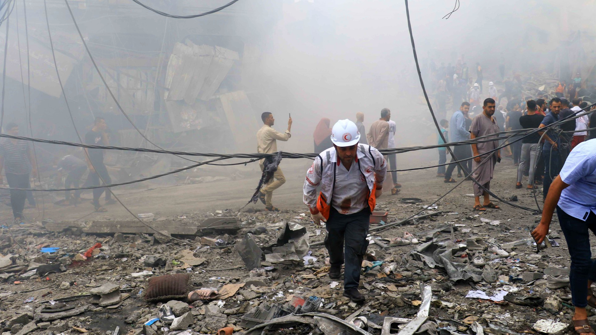 A Palestine Red Crescent Society volunteer walks through rubble to assist people in Gaza during the conflict.