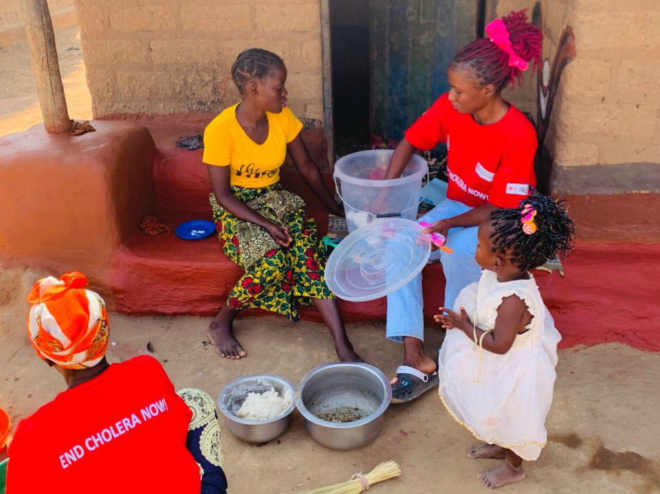 A ZRCS volunteer demonstrates the correct process for treating water using chlorine during a household session — empowering families to practice safe water handling.