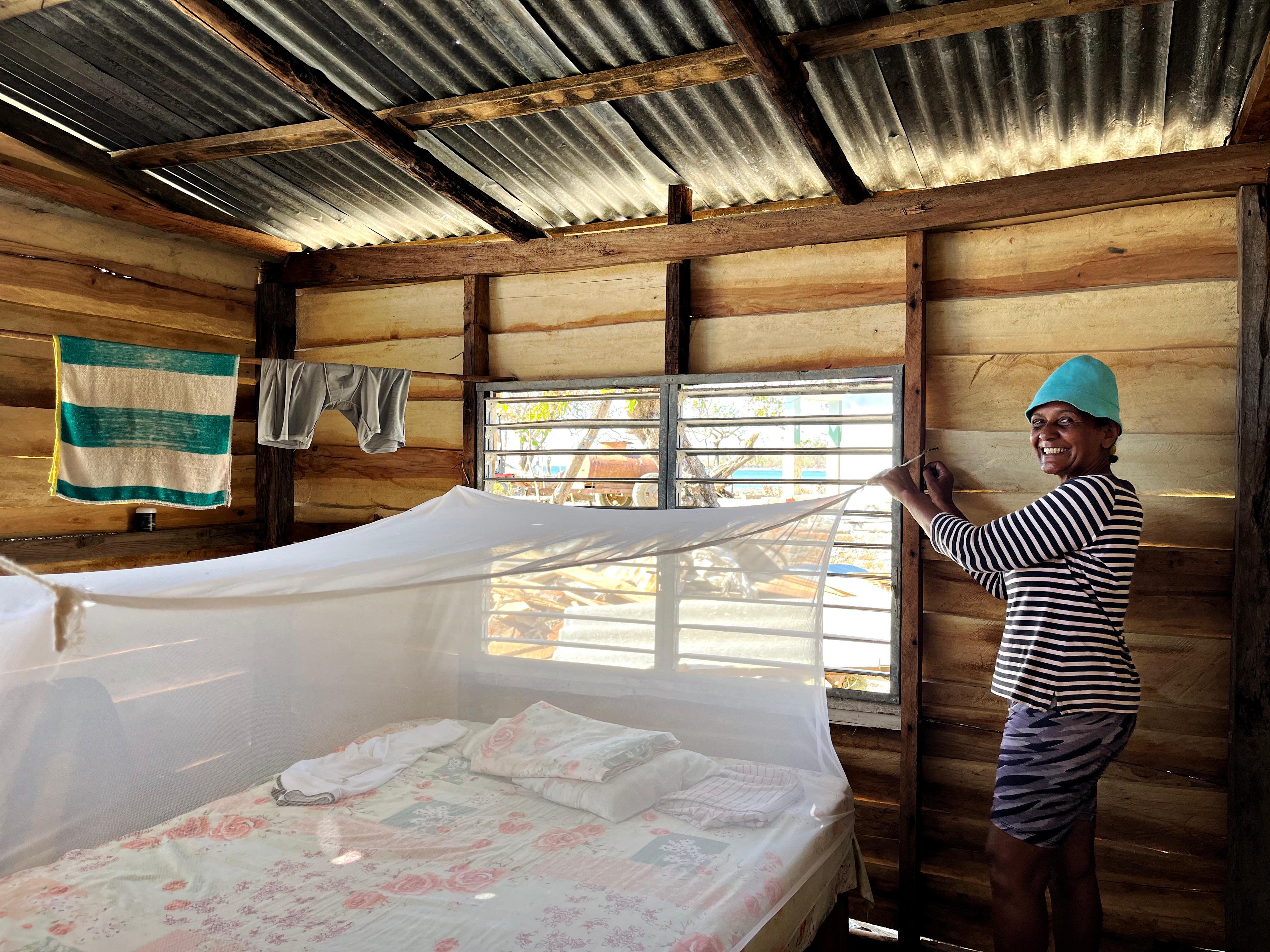 Smiling, Berta González shows off the mosquito net installed on her bed. She received it from the Cuban Red Cross to protect her from mosquito-borne diseases.