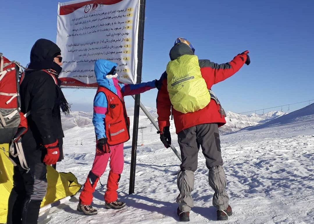 An Iranian Red Crescent volunteer speaks with hikers during a winter patrol in the mountains, where teams work to prevent accidents in avalanche-prone areas. 
