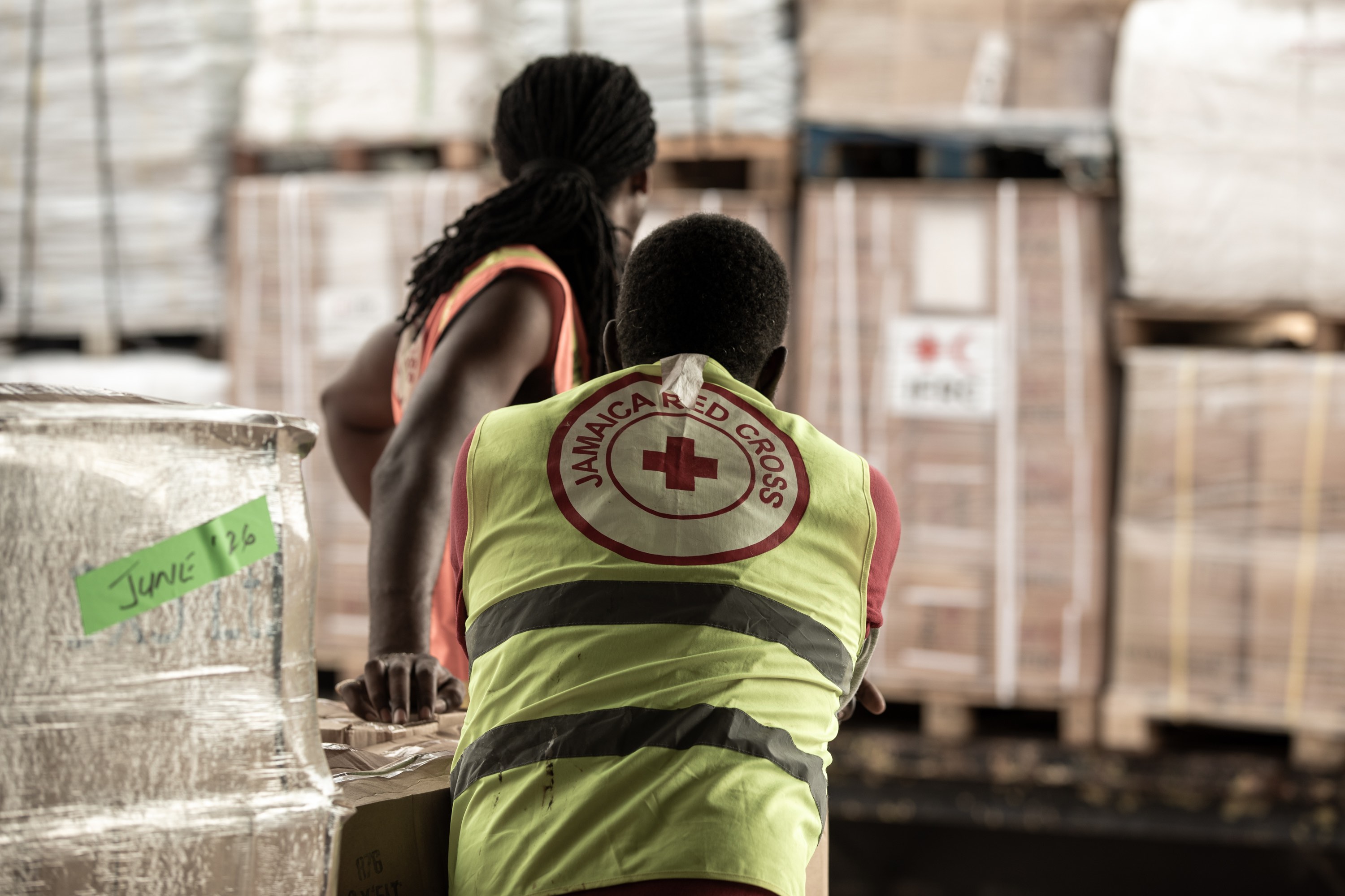 At the Jamaica Red Cross headquarters, volunteers unload 50 tons of critical supplies such as tarpaulins, hygiene kits, shelter kits, blankets and solar lamps into a warehouse before distribution. Supplied with support from IFRC, the items will help support 500 families.