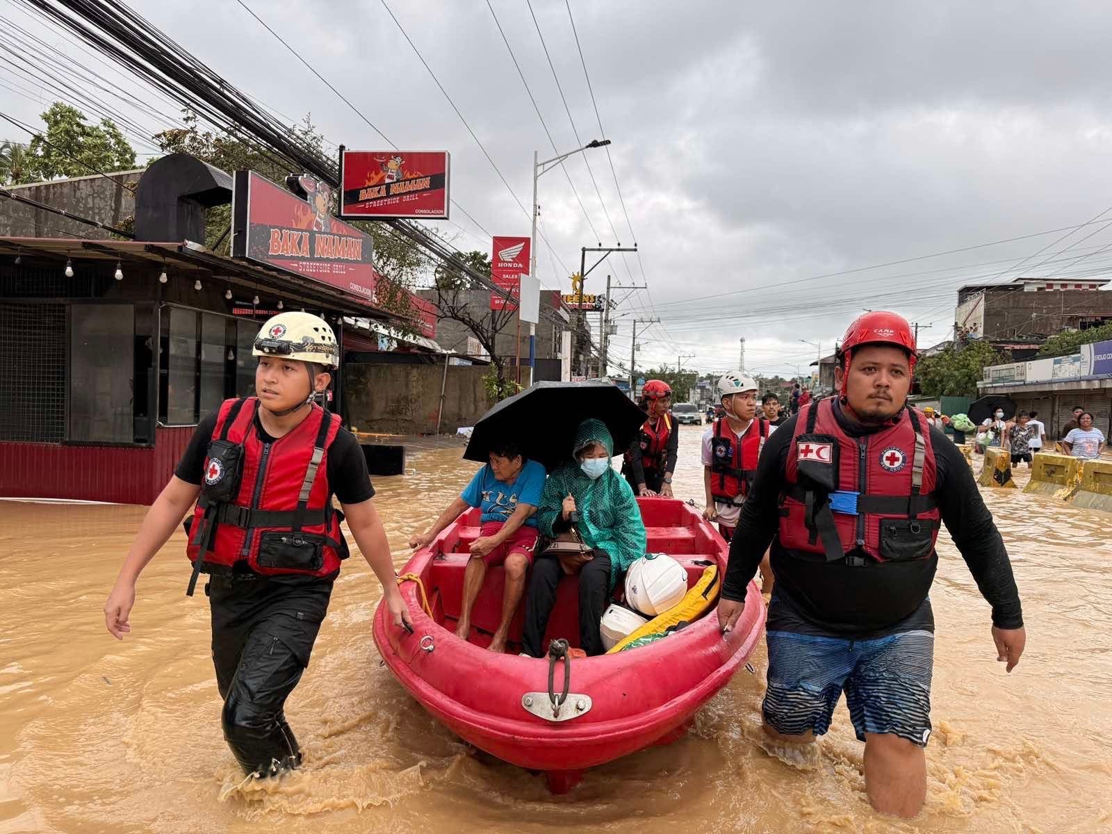 Un grupo de socorristas de la Cruz Roja de Filipinas avanza por las aguas inundadas remolcando una pequeña embarcación de rescate que utilizan para llevar a las personas a un lugar seguro tras el paso del tifón Kalmaegi, que tocó tierra en ocho ocasiones en el centro de Filipinas entre el 3 y el 5 de noviembre de 2025. 