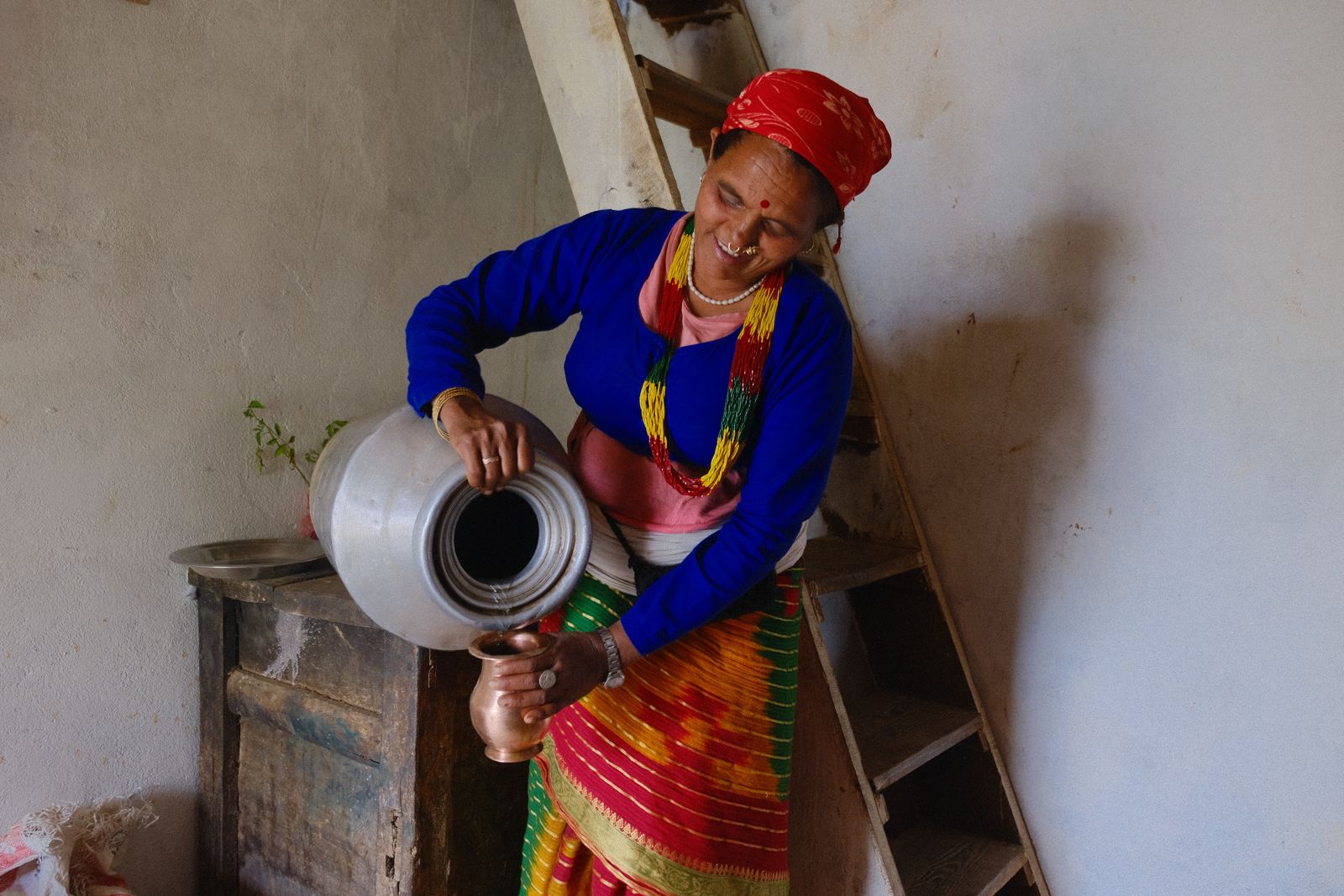Supari Luhar pours clean, safe water from a jug in her hillside home. 