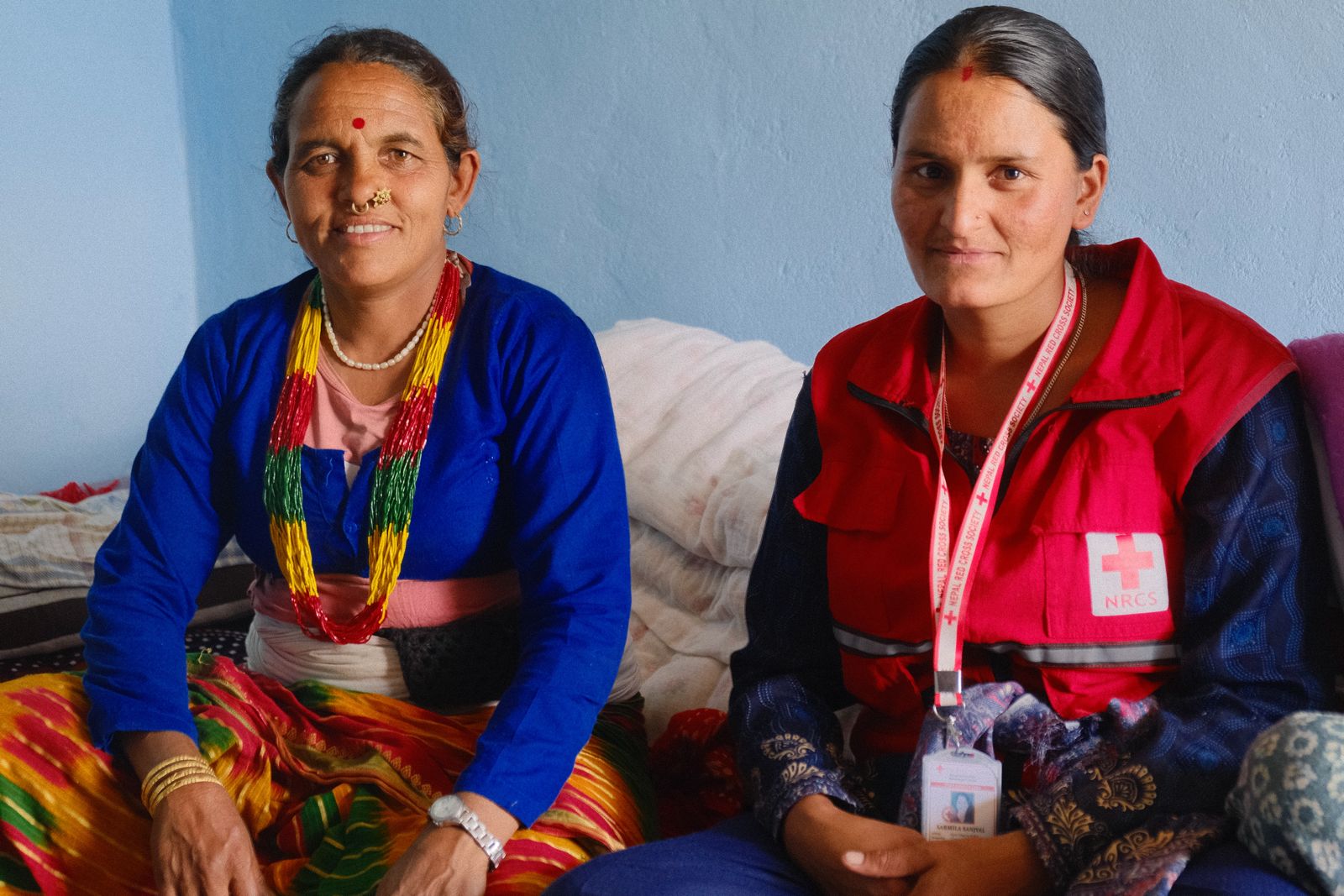 Supari sits beside Karmila, a Nepal Red Cross volunteer who is involved in the water, sanitation and hygiene project.