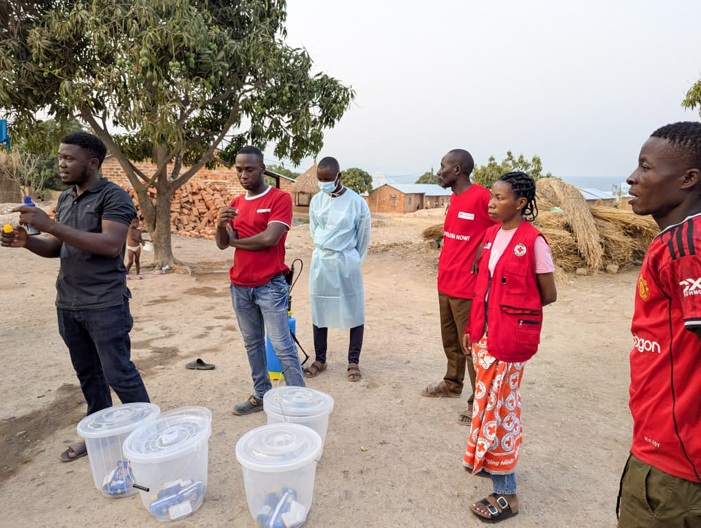 Volunteers conduct a practical water purification demonstration, ensuring community members understand and adopt life-saving hygiene measures. 