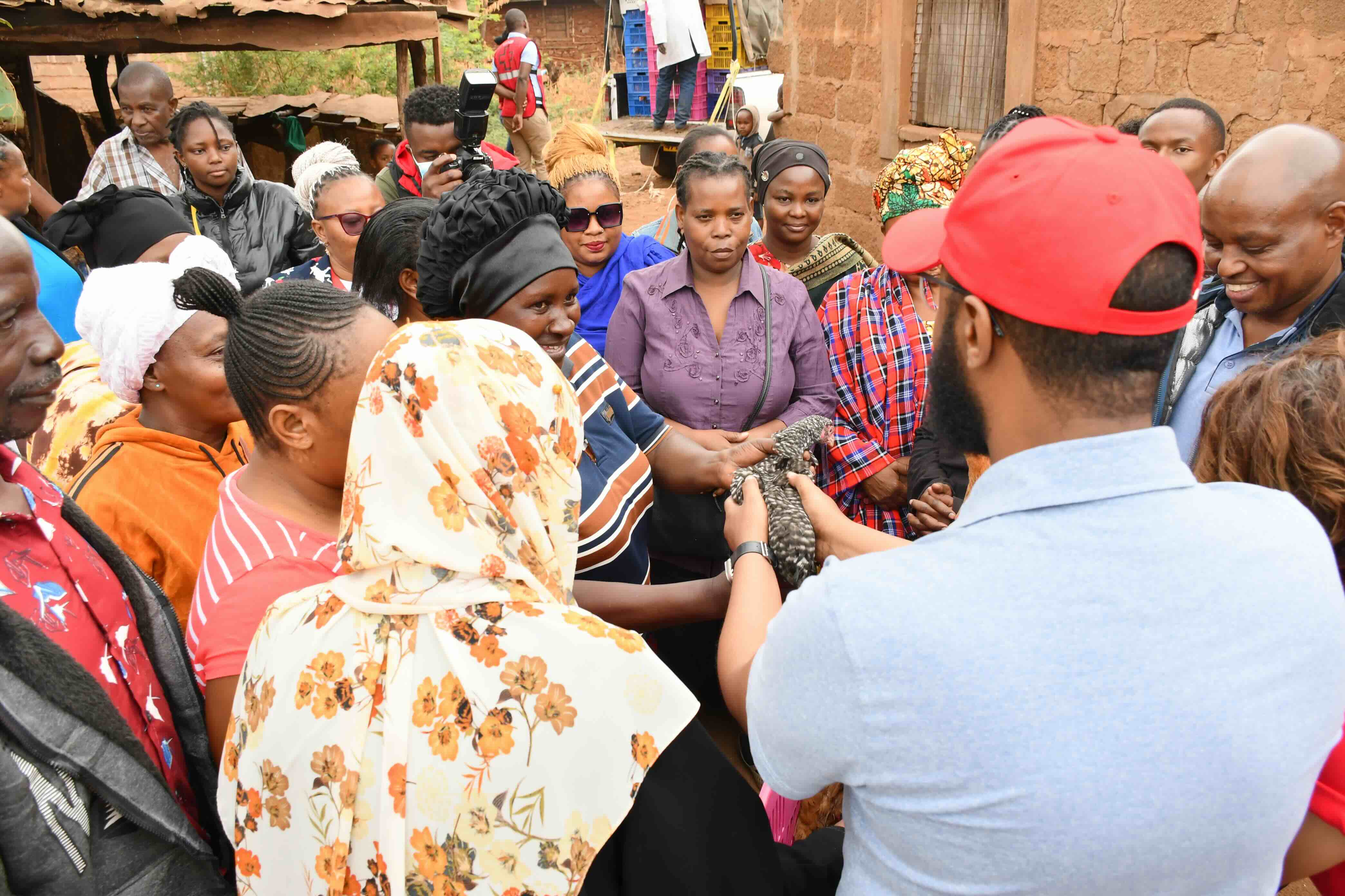 People gather to inspect and celebrate the poultry raised on low-cost, locally produced feed.