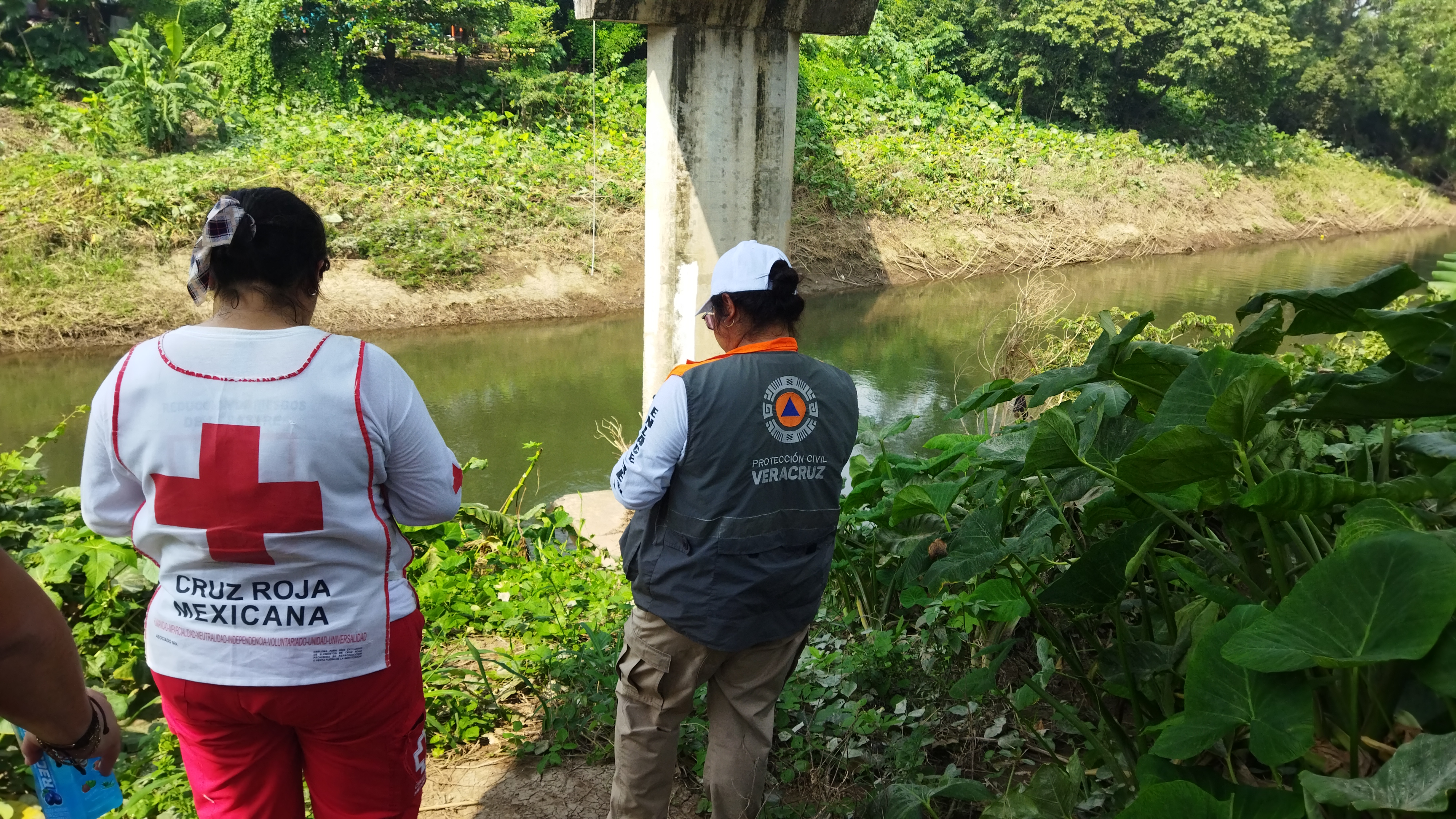 A Mexican Red Cross volunteer and a civil protection worker take measurements of the water level under a bridge over the Cotaxtla River in Veracruz, Mexico.