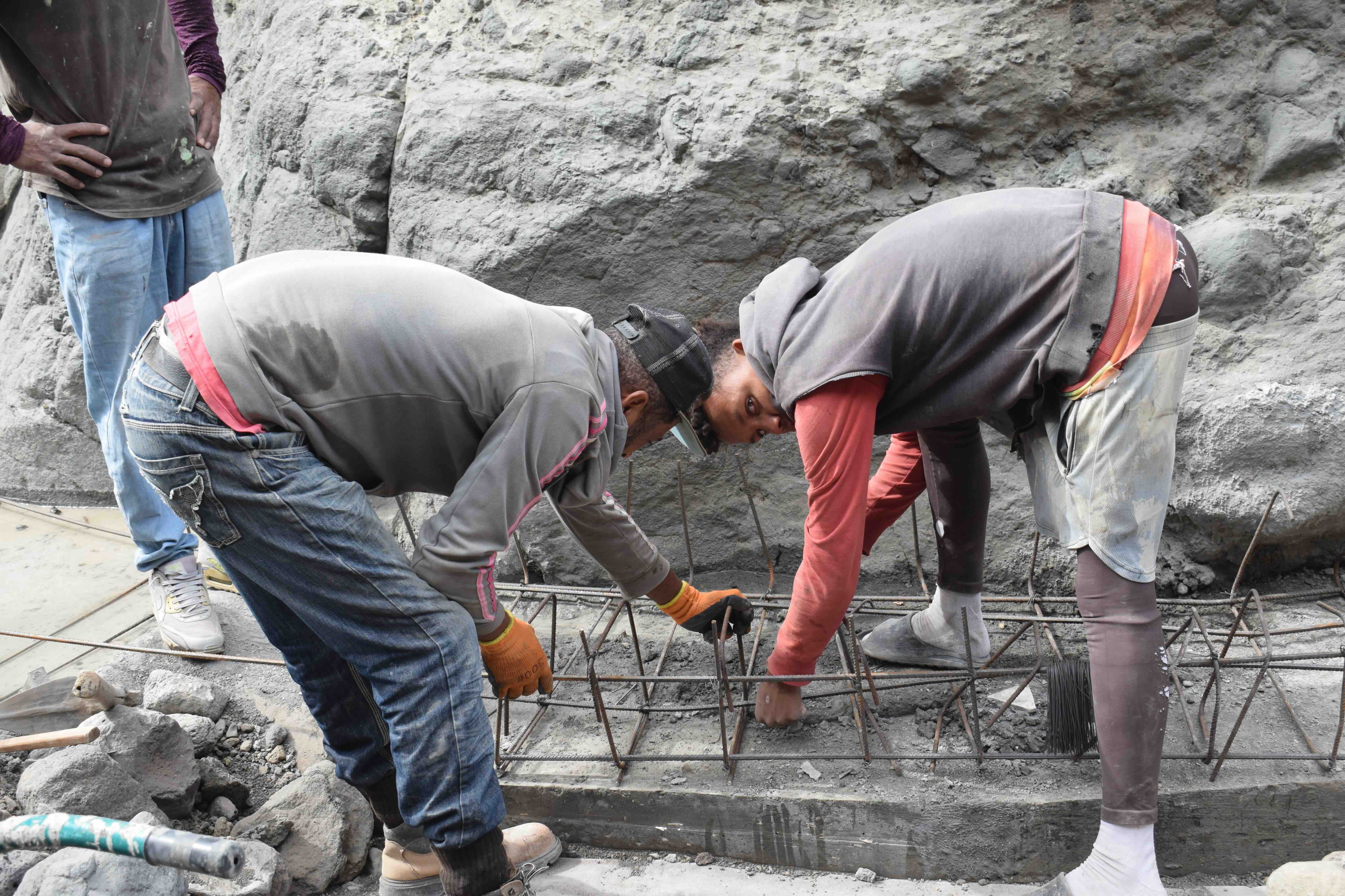 Two local residents work on rehabilitating a local water supply system that was badly damaged in the flood. The work is supported through a cash-for-work approach, in which the IFRC provides materials and pays community members who carry out the rehabilitation themselves.