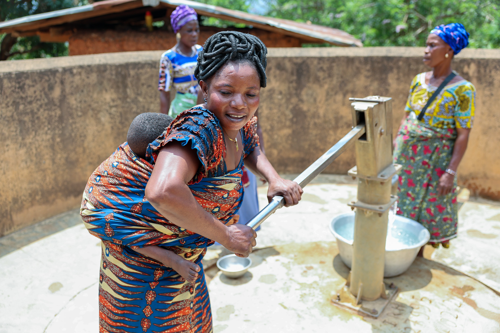  In the village of Lonfoloko in the west-African nation of Togo, a volunteer and member of the local Mothers Club pumps water from a well the group manages — part of the club's daily work keeping their families and communites healthy, clean and safe.
