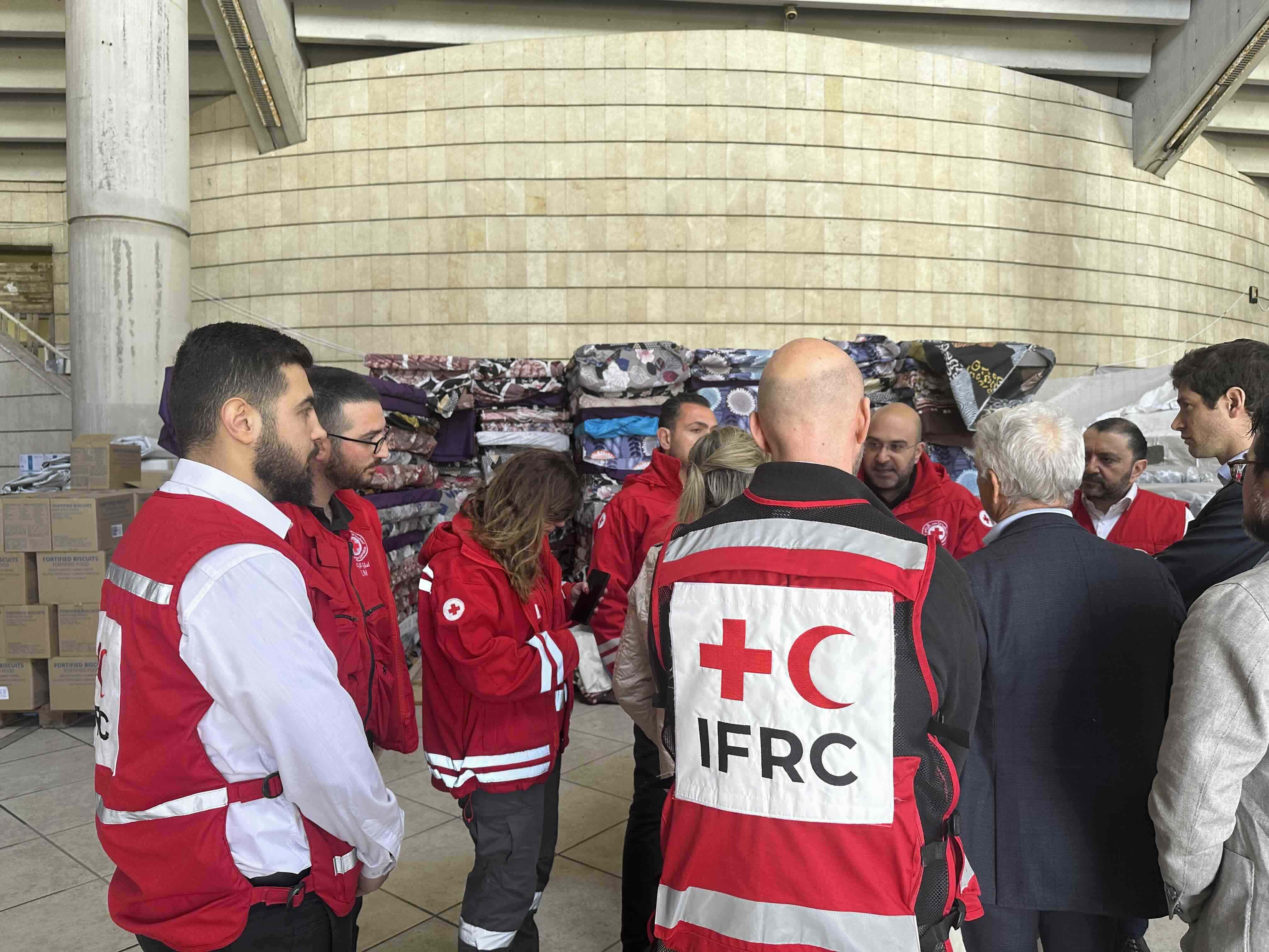Teams from the IFRC and Lebanese Red Cross plan their delivery of support to people staying at the Camille Chamoun Sports City Stadium in Beirut.