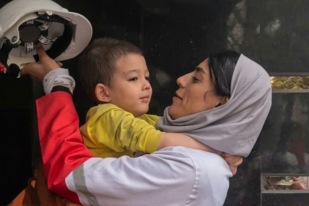 A child rescued following an attack finds comfort in the arms of an Iranian Red Crescent aid worker.