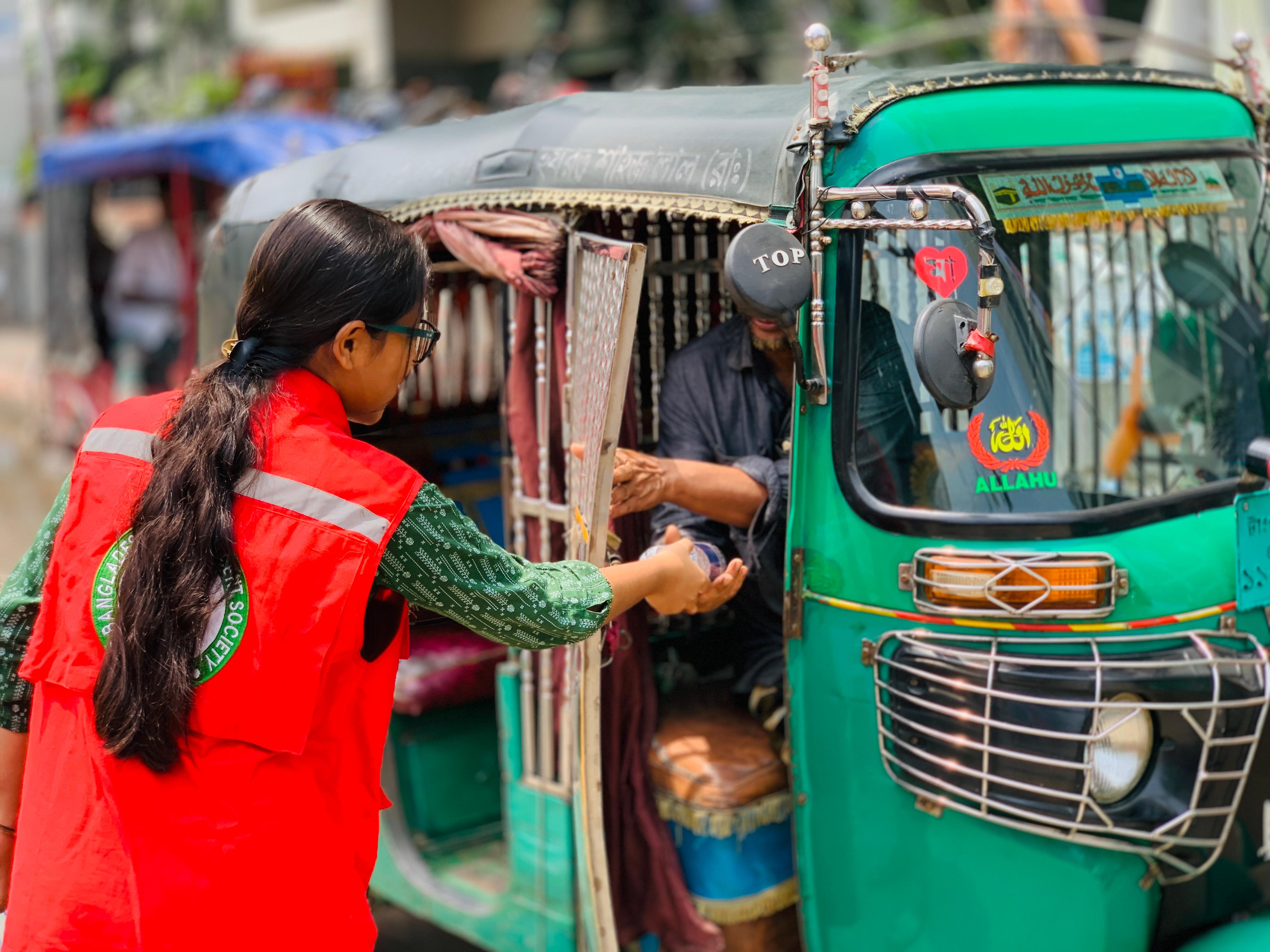 In response to the growing threat of extreme heat driven by climate change, Bangladesh Red Crescent volunteers distribute drinking water to people working under the sun (including those working inside public transport vehicles) and disseminated key messages on heatwave preparedness and protection. 