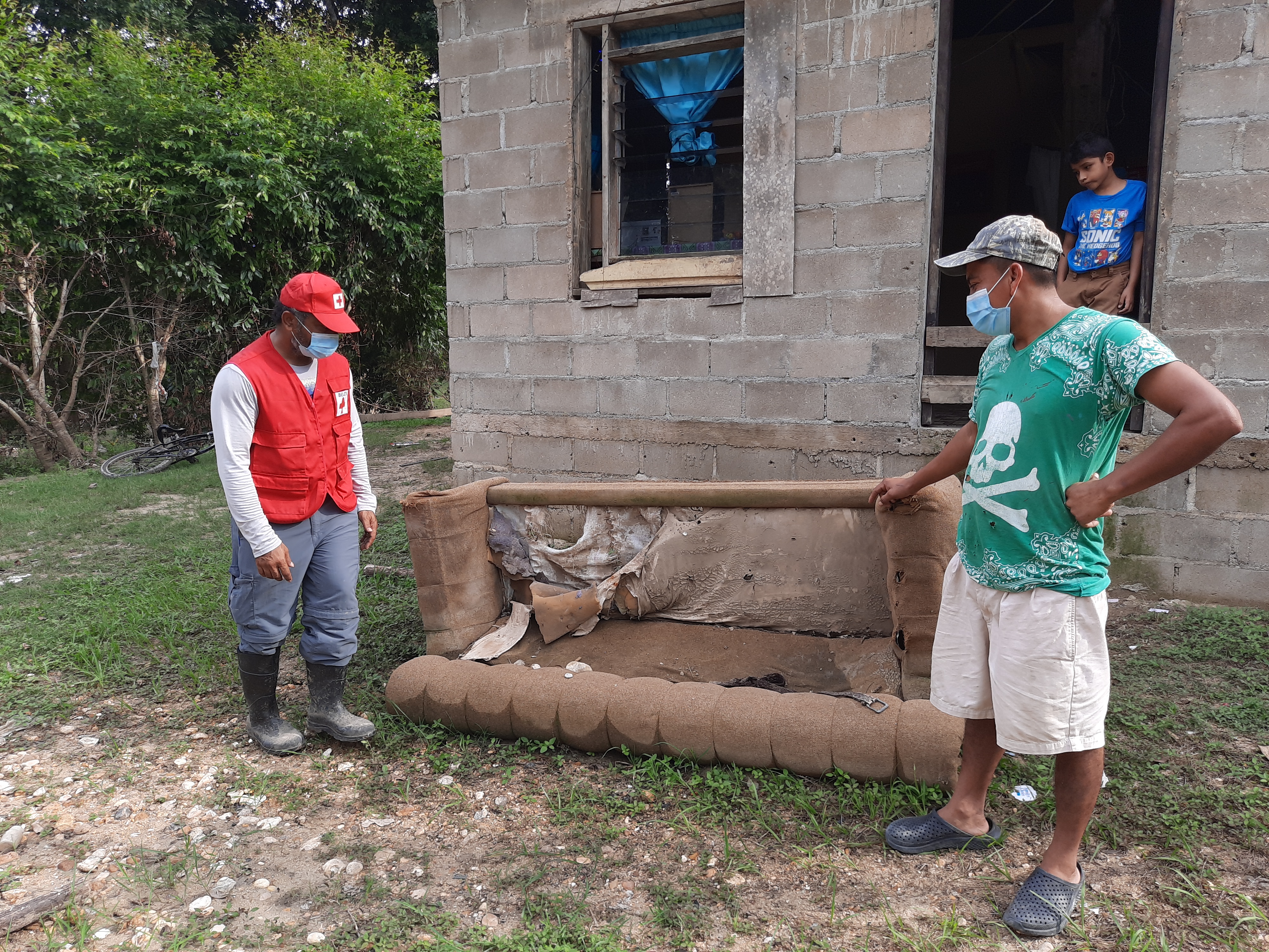 Larry Jimenez shows Belize Red Cross staff member, Terence Woodbye some of the damages to his furniture following flooding from Hurricane Eta