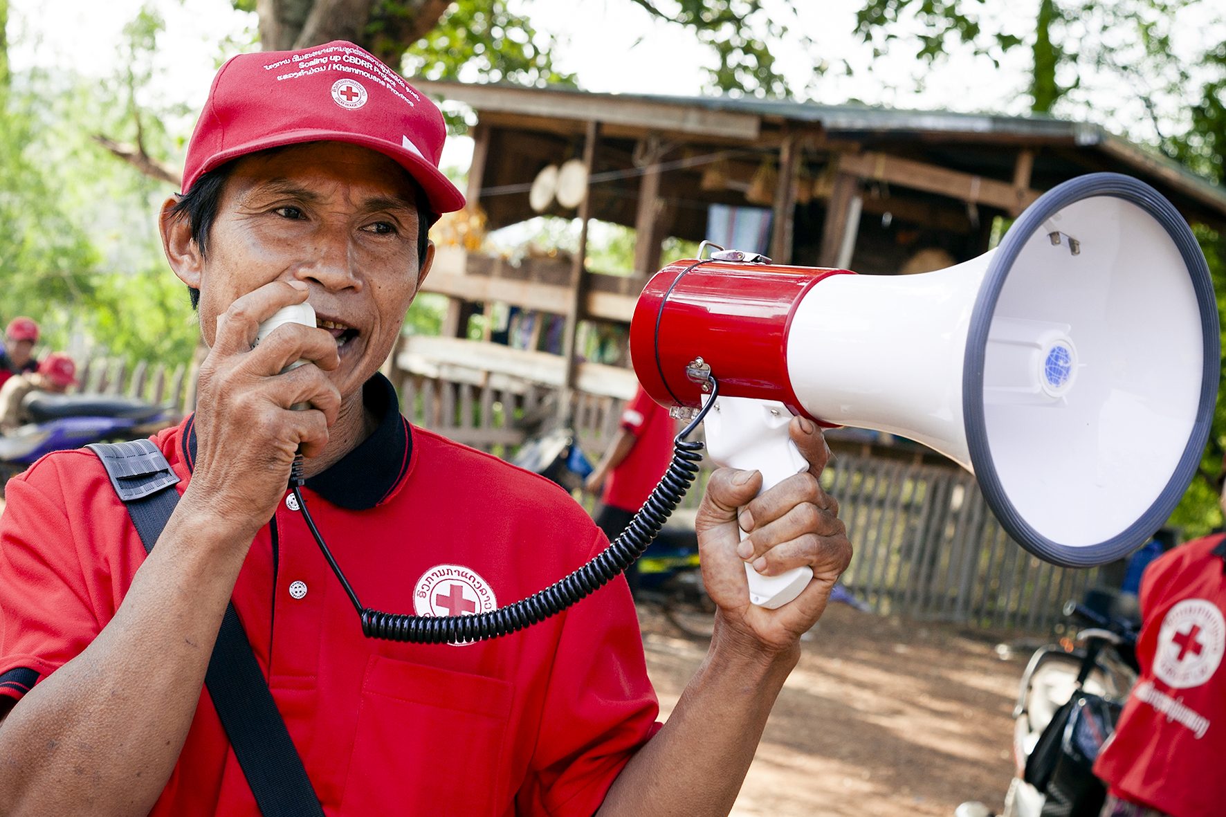 A member of a Village Disaster Protection Unit announces evacuation warnings during a disaster simulation exercise in Khammouane Province, Laos in 2015