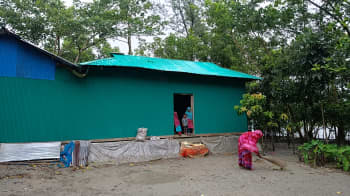 Noyon Akter sweeps up the yard in front of the new shelter provided by the Bangladesh Red Crescent Society, with support from the IFRC. Photo: Bangladesh Red Crescent Society.