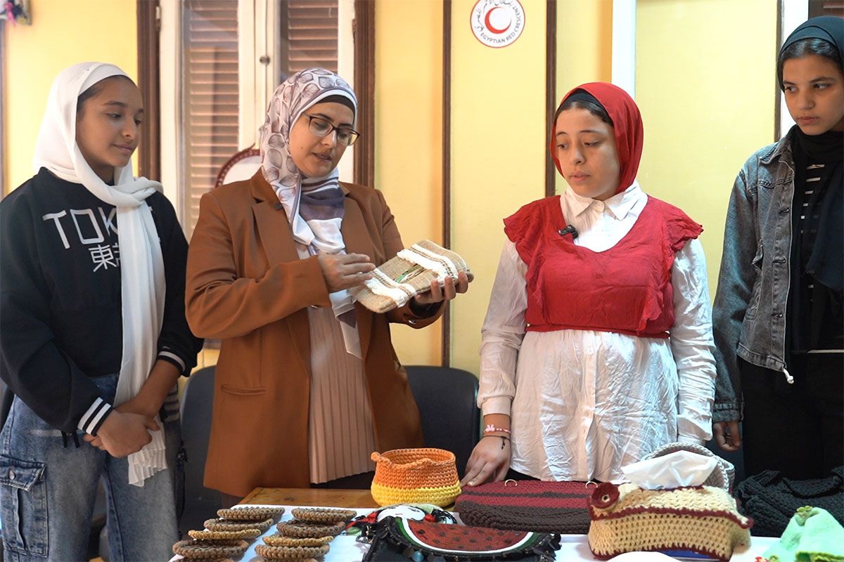 سحر شعبان تحمل حقيبتها المفضلة، وتقف محاطةً بطالباتها
