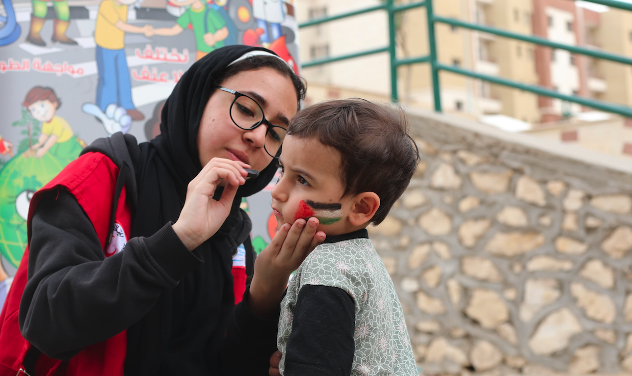 A volunteer for the Egyptian Red Crescent gives her time to provide some joy and a sense of normalcy to people who fled conflict in Gaza.
