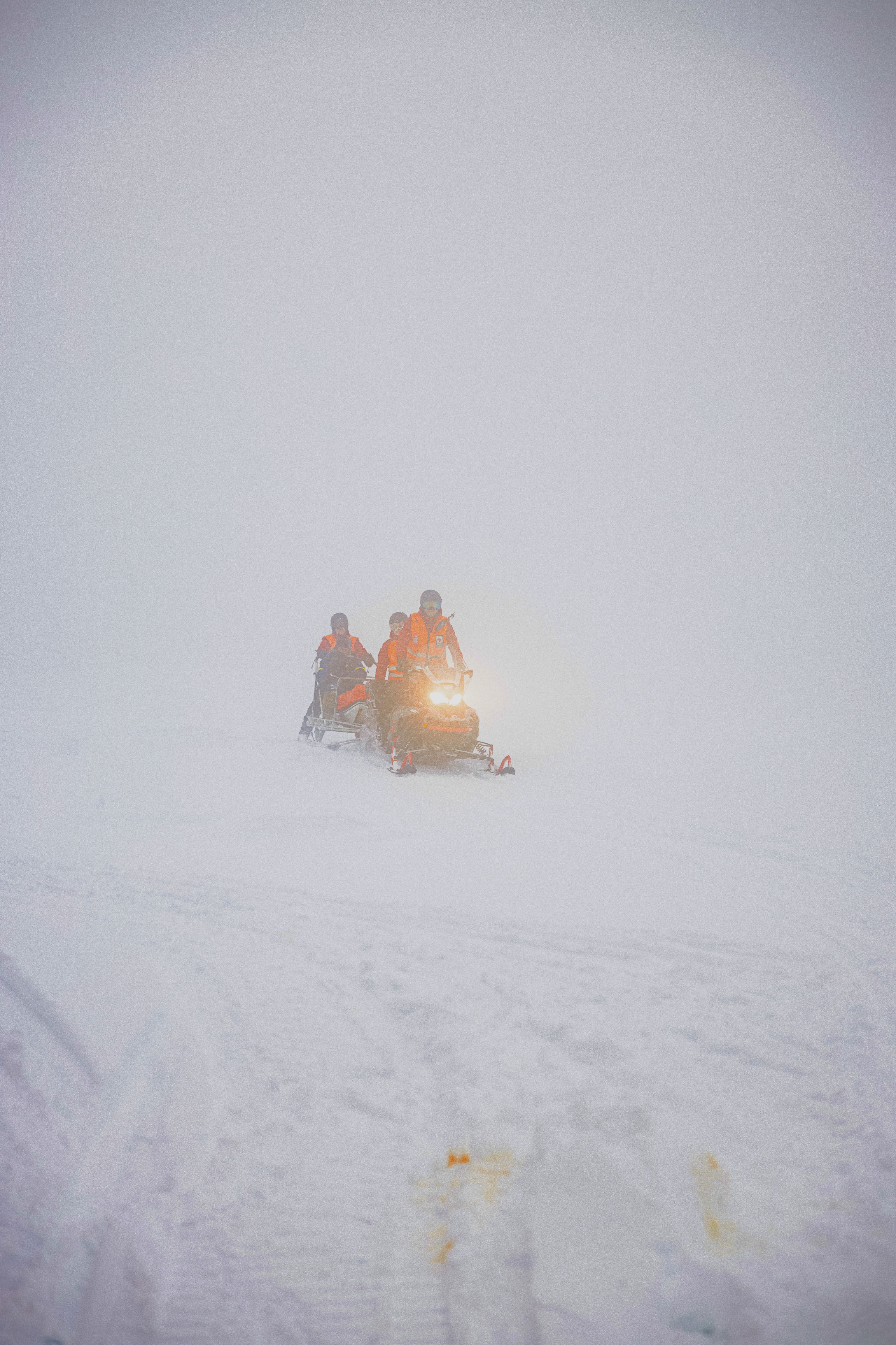 Red&nbsp;Cross volunteers ride snowmobiles across a snowy field in dense fog, relying on what they sometimes call "snow how"  to help them stay safe during emergency rescue operations. Photo: Aleksander&nbsp;Båtnes/Norwegian Red Cross