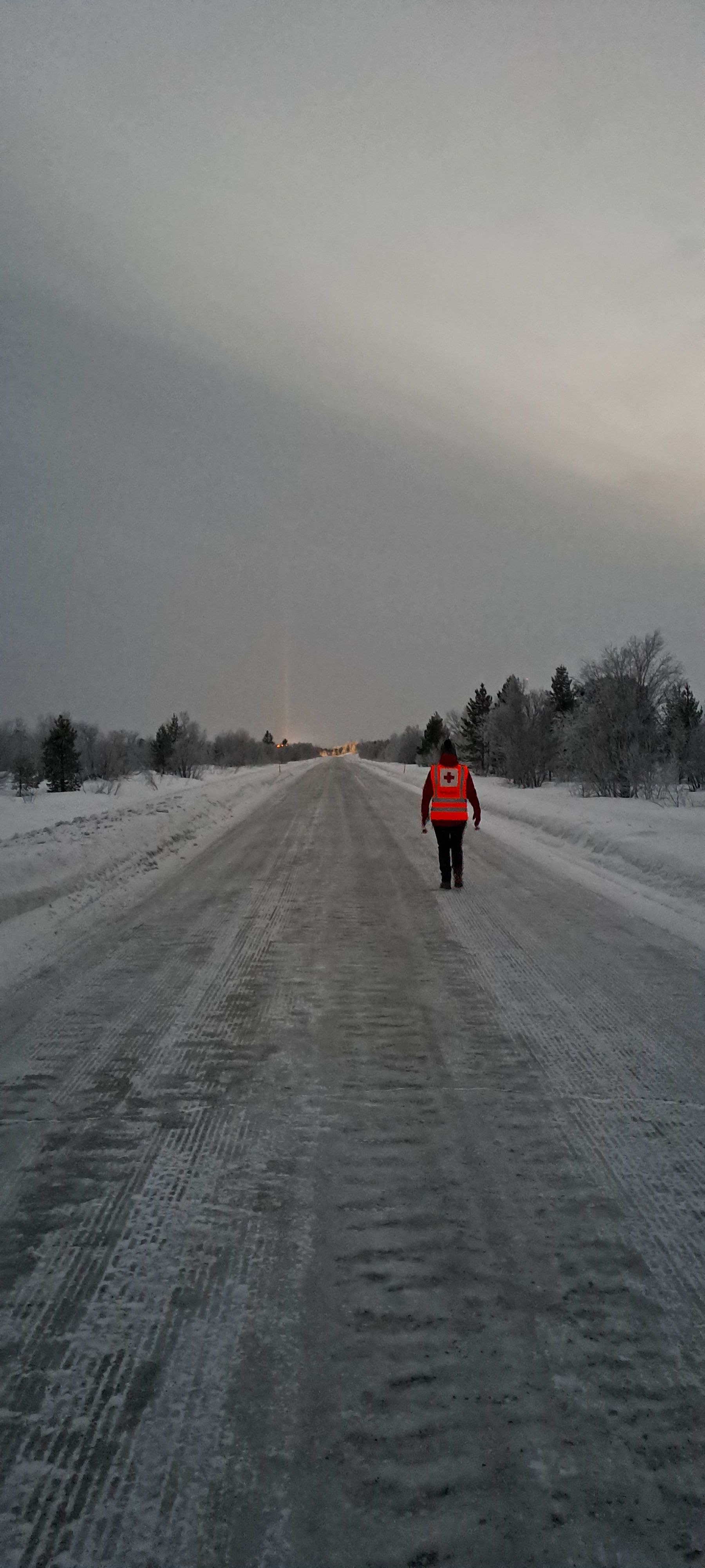 A volunteer walks along an empty arctic road. Photo: Gabriella Jurisic&nbsp;Ottesen/Norwegian Red Cross