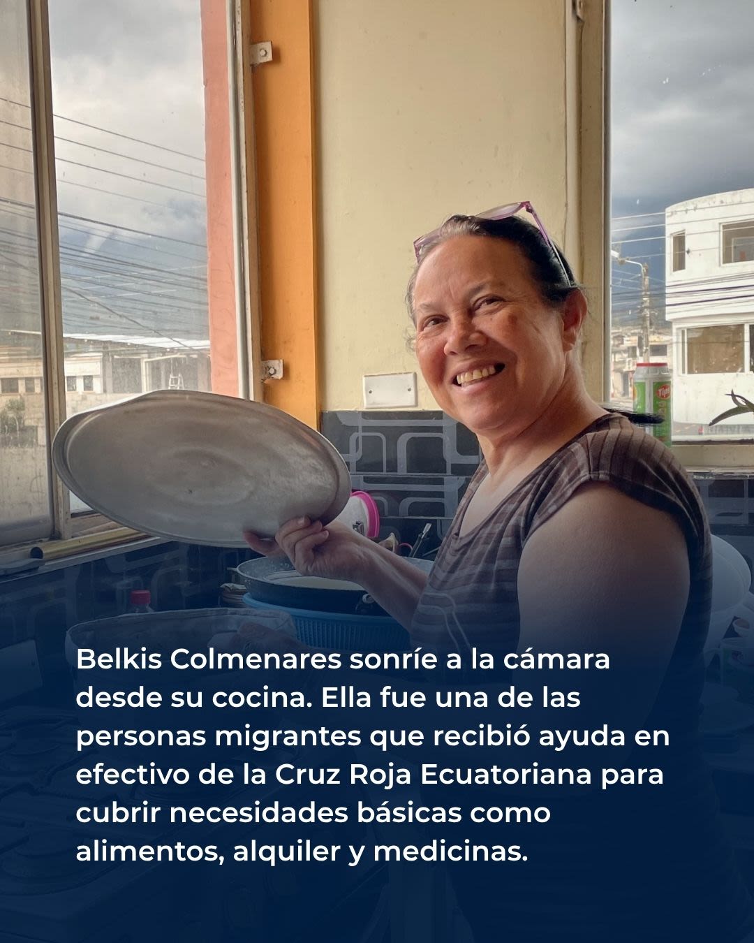 Belkis Colmenares sonríe a la cámara desde su cocina. Ella fue una de las personas migrantes que recibió ayuda en efectivo de la Cruz Roja Ecuatoriana para cubrir necesidades básicas como alimentos, alquiler y medicinas.
