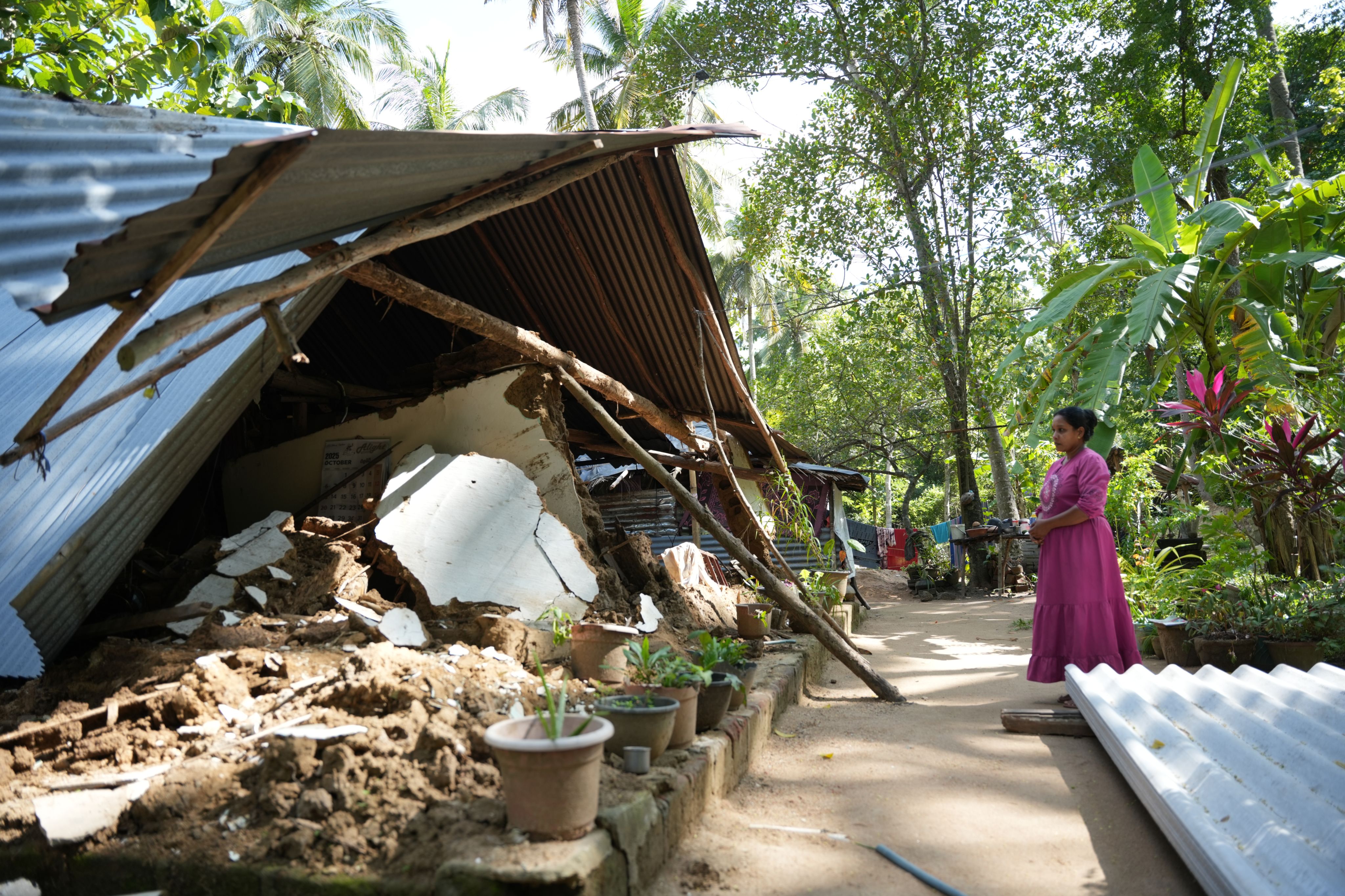 R M Namali Dilrukshi looks over what is left of her home following the ravaging floods.