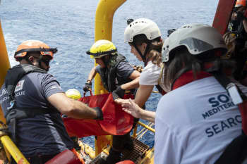 Camille Coletta helps fellow crew members from the IFRC and SOS MEDITERANEE bring an injured person aboard the Ocean Viking.