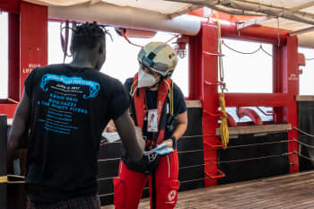 IFRC's Sara Mancinelli welcomes a man on board the Ocean Viking who was just rescued from a small boat, lost at sea.