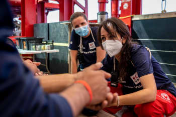 Sara Mancinelli listens to a survivor from a boat in distress that was rescued by the Ocean Viking.