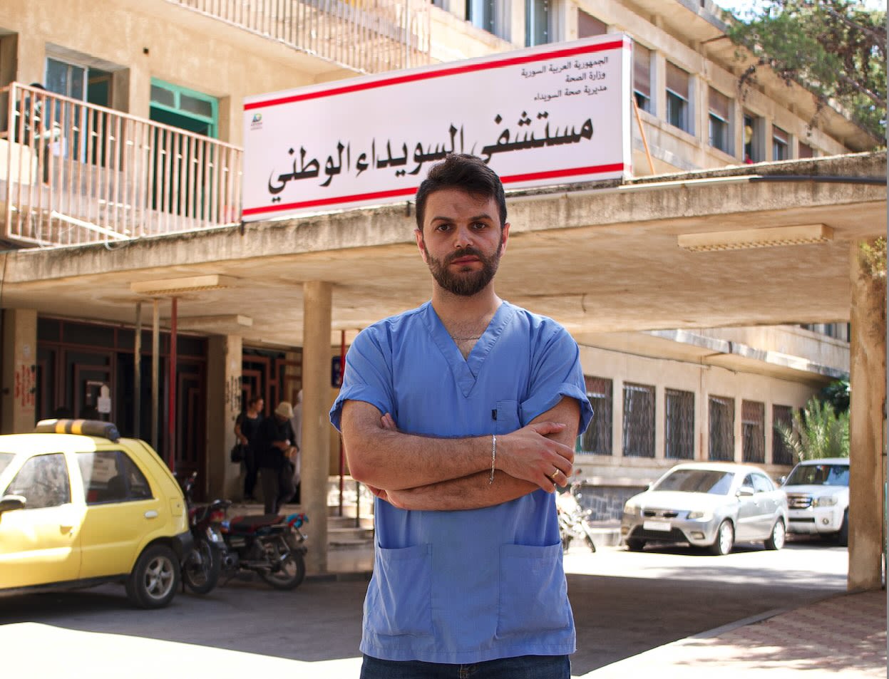 Dr. Obeida Abou Fakher stands in front of the hospital where he works in Syria.