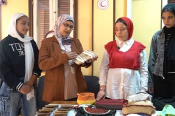Sahar Shaaban holds her favorite handbag as she stands surrounded by her students