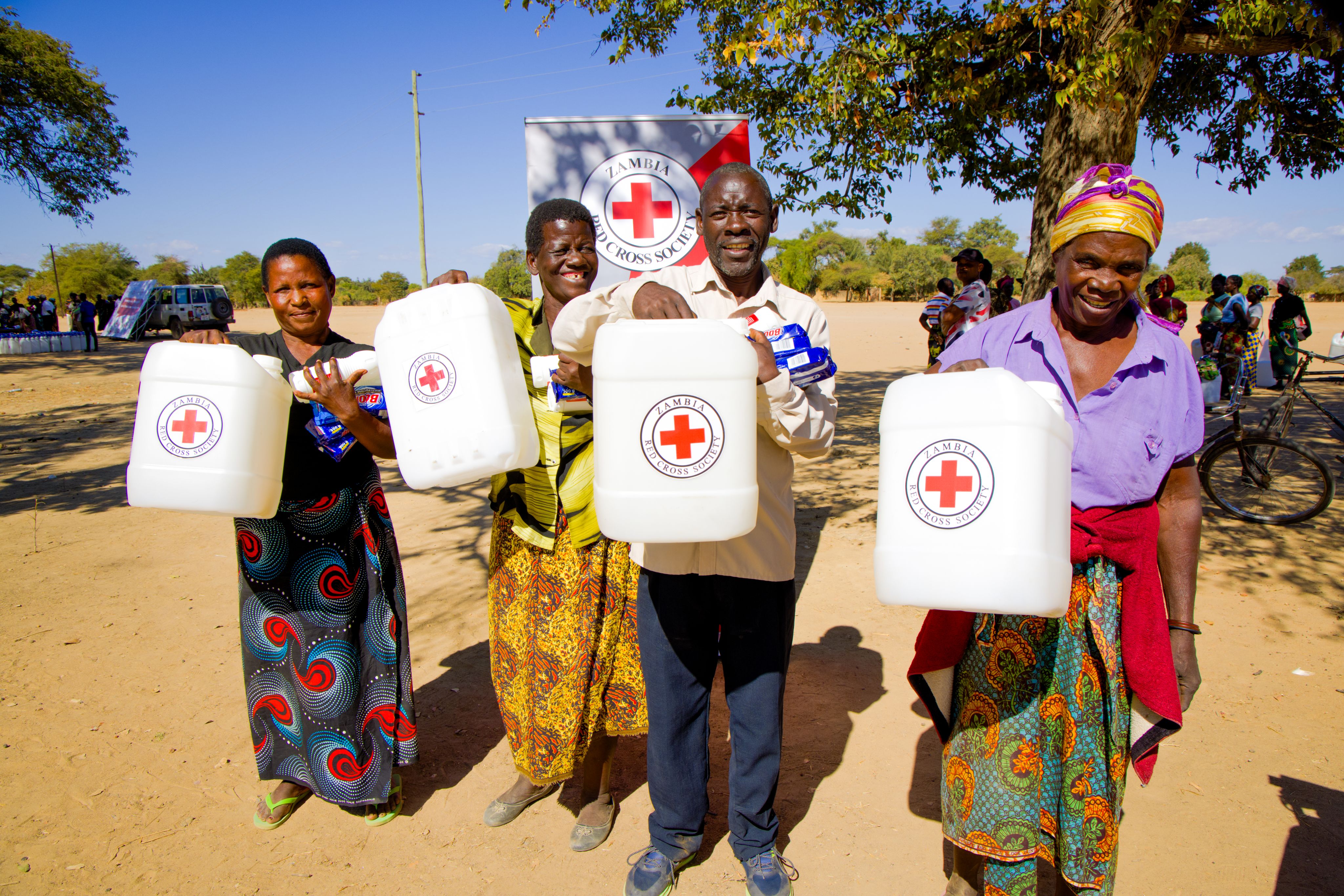 Recipients of Red Cross support display their water containers with pride. Families are now better equipped to store safe water and maintain hygiene amid drought.