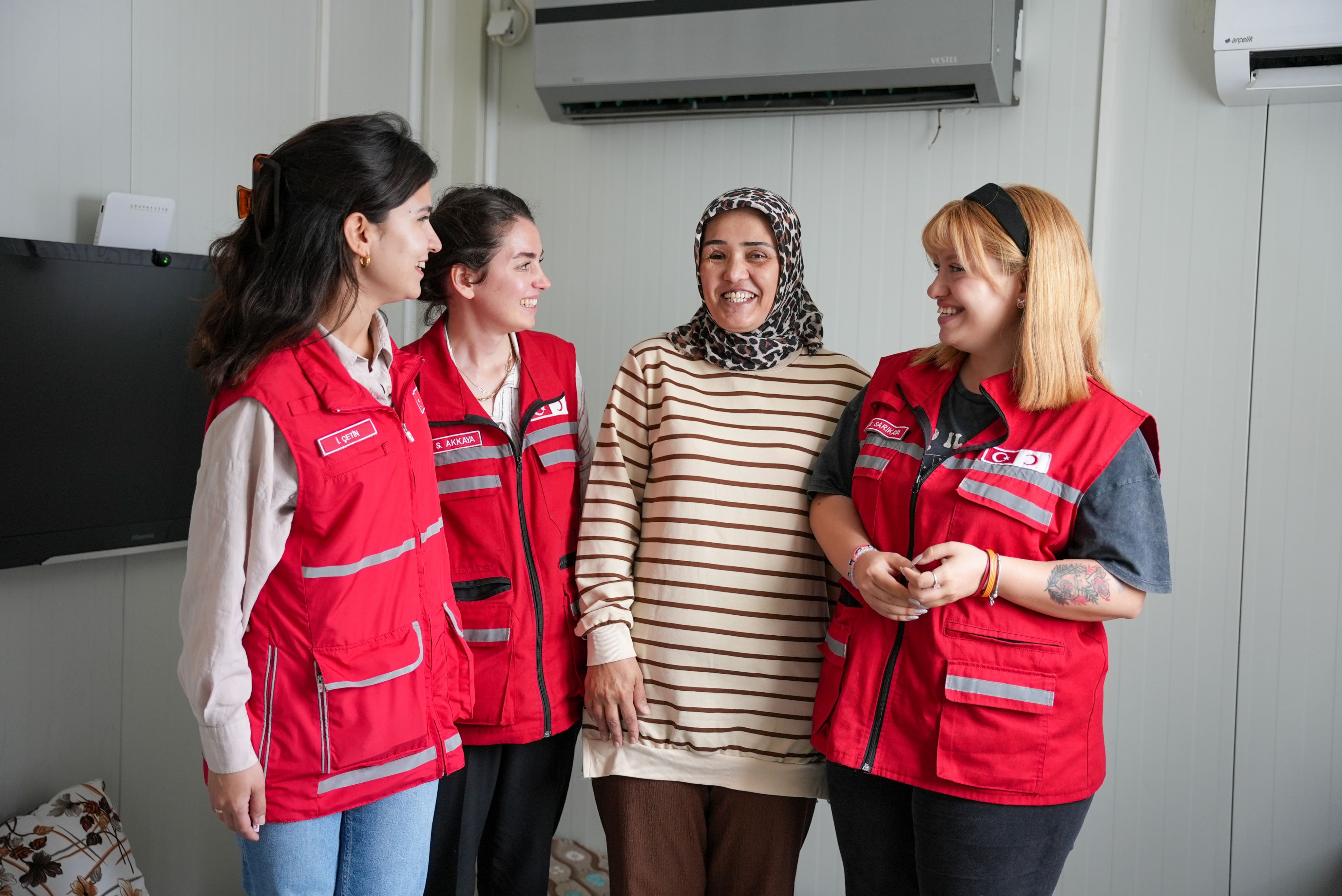  A survivor of the 2023 earthquakes in Turkiye and Syria, Canan (third from left) receives a visit from Turkish Red Crescent staff.