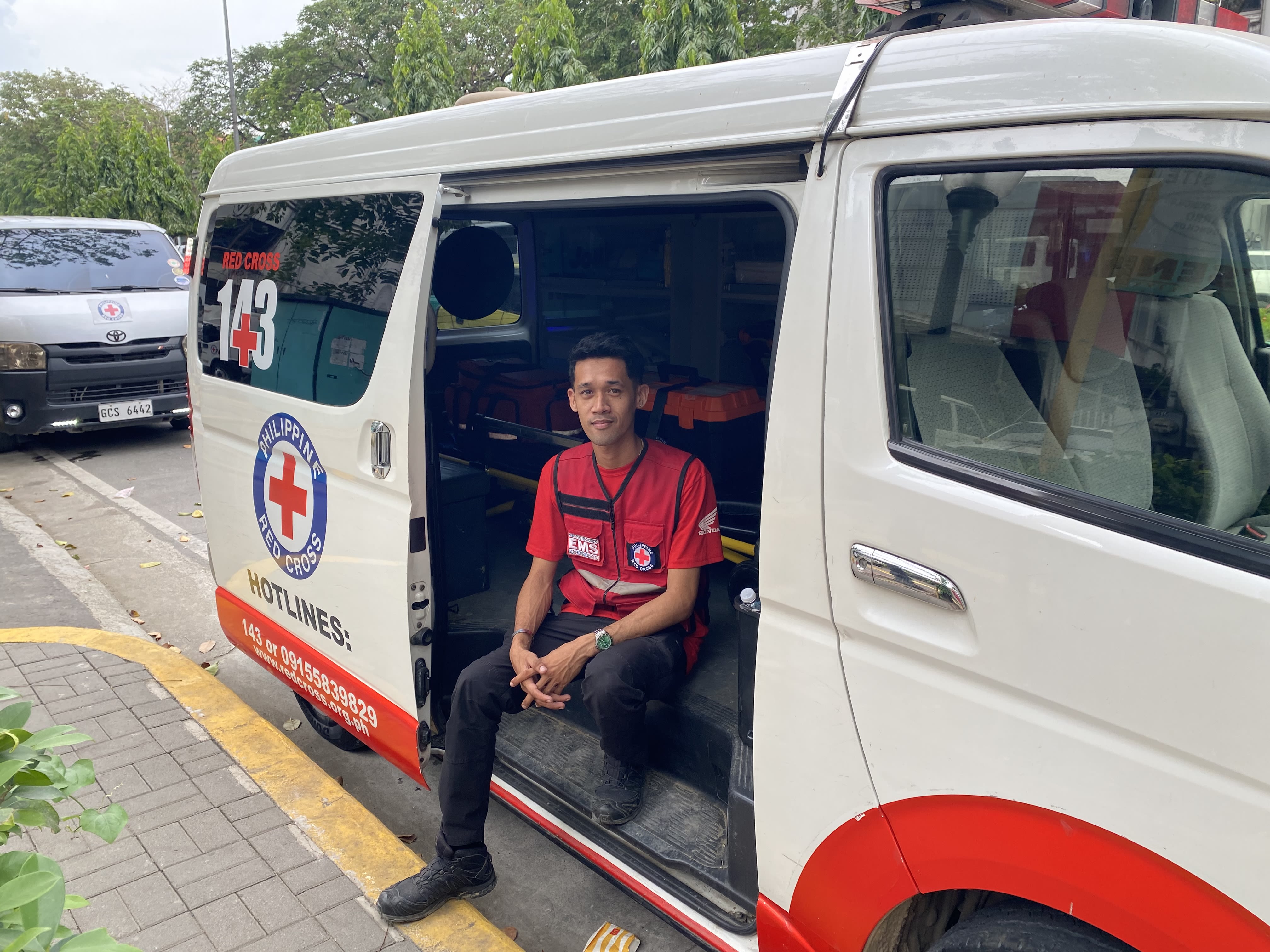 Christian Rosal sits inside the ambulance he drives for the Philippine Red Cross Society.