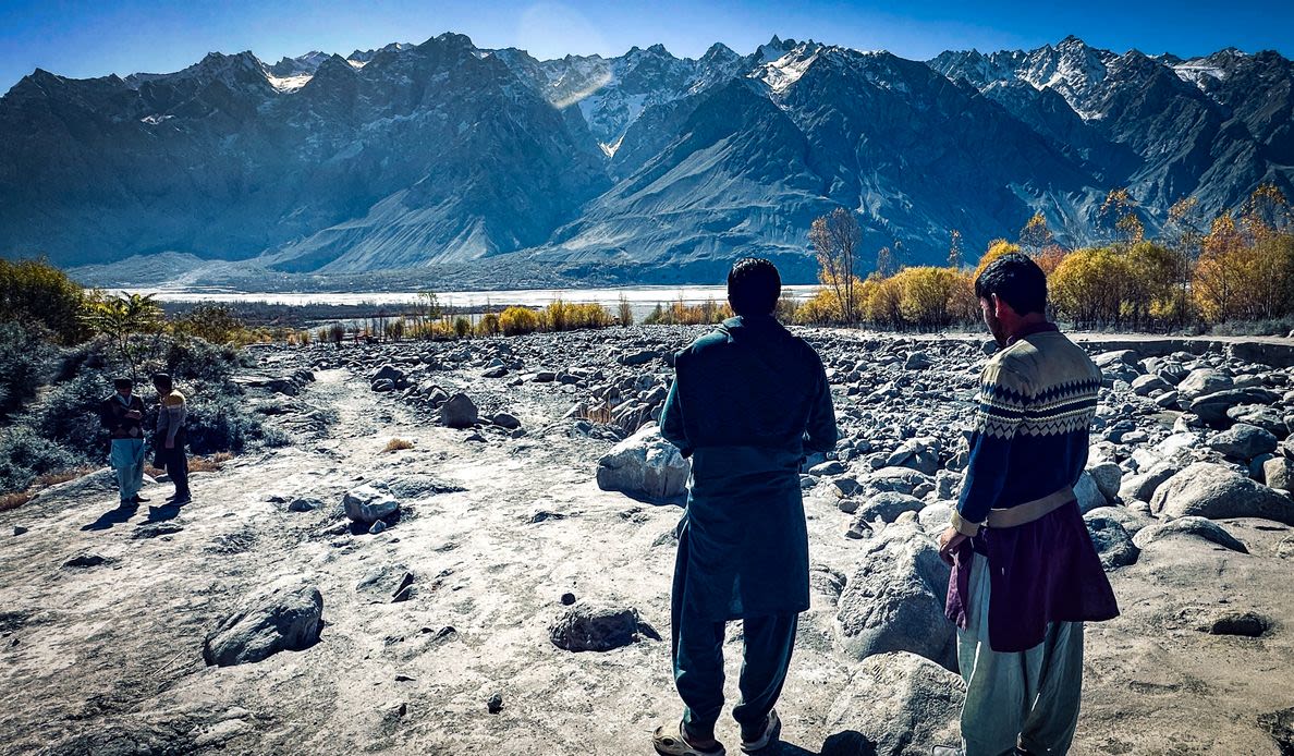 Standing where apricot trees once produced fruit for local growers, two men from Hurchus survey the boulder-strewn path of the sudden flood.