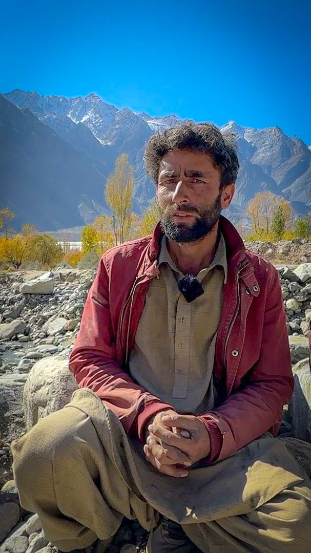 Abuzar Hussain&nbsp;sits on a field of boulders washed down by the floods near his home.