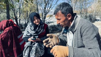 A man who lives in Hurchus village speaks with Aqueela Zehra, a volunteer with the Pakistan Red Crescent during a detailed assessment of the villagers' needs following the floods. 