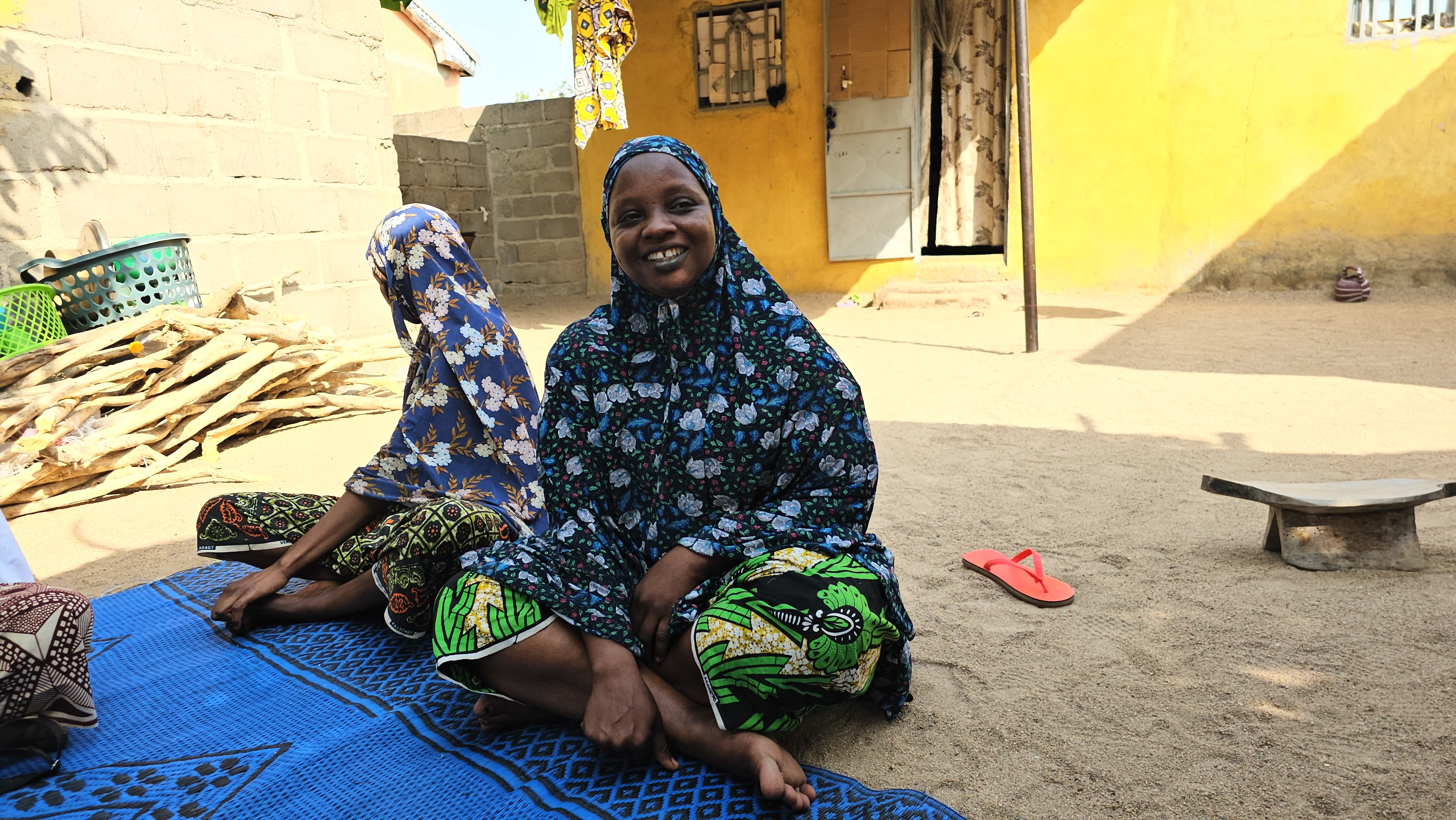 Tchinabi Thérèse (right), president of the local mothers’ club, explains basics of menstrual hygiene and pre-natal care to a group of young women, and some parents, in a village in Cameroon’s Far North region. 