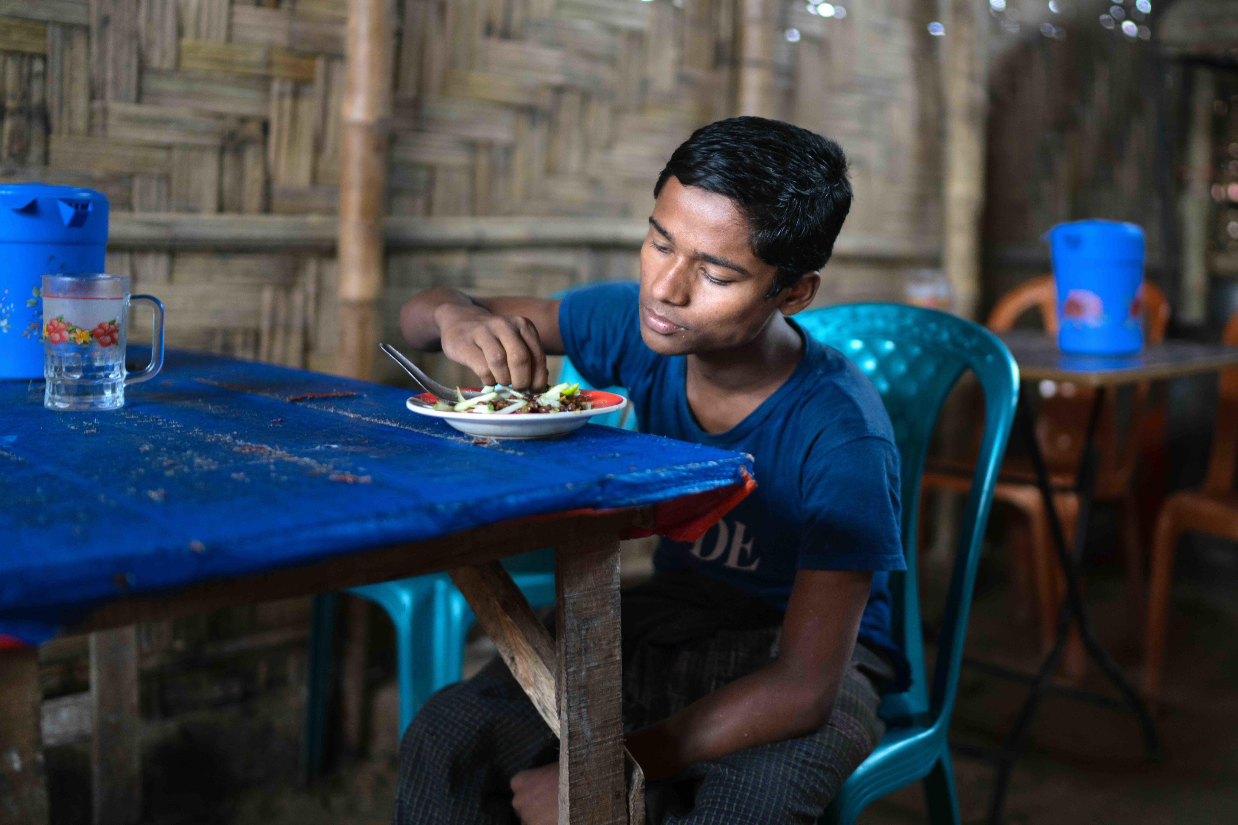 Mohammed Shahid has a meal inside a new shelter constructed with support from the Bangladesh Red Crescent and the Programmatic Partnership.