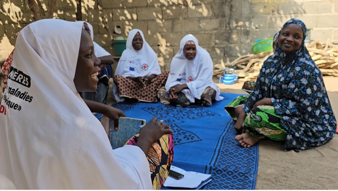 Tchinabi Thérèse (right), president of the local mothers’ club, explains basics of menstrual hygiene and pre-natal care to a group of young women, and some parents, in a village in Cameroon’s Far North region. 