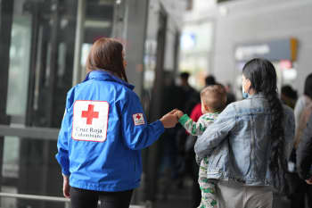 A woman from the Colombian Red Cross accompanies a mother and her baby who have returned to the country.