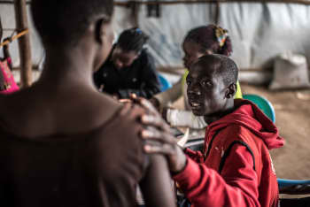 Robert Agele, a 24-year-old volunteer with the Uganda Red Cross counsels an unaccompanied minor refugee at a collection point a few kilometers from the Uganda South Sudan border.