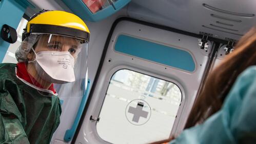 A Red Cross volunteer transporting a patient to the hospital in an ambulance