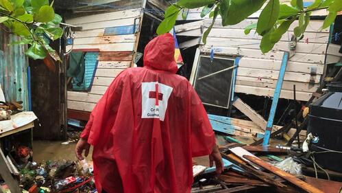 A Guatemalan Red Cross volunteer arrives at a home severely damaged by Hurricane Eta in November 2020