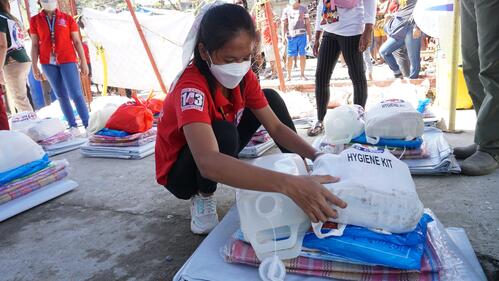 A Philippine Red Cross volunteer prepares supplies and relief for typhoon affected victims