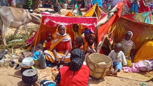 A family who fled conflict in Sudan sit together in a tent across the border in Chad in May 2023 where they receive assistance from the Chad Red Cross.