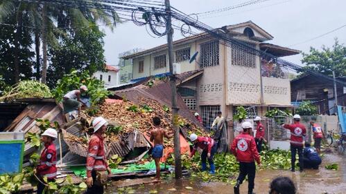 Myanmar Red Cross Society volunteers clean up an area of Thingankyun township which was struck by Cyclone Mocha in May 2023.