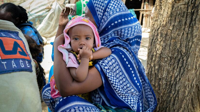 أم تحمل ابنتها في مخيم للنازحين في كونيبا في إثيوبيا